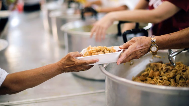 Food in bowl being passed in assembly line