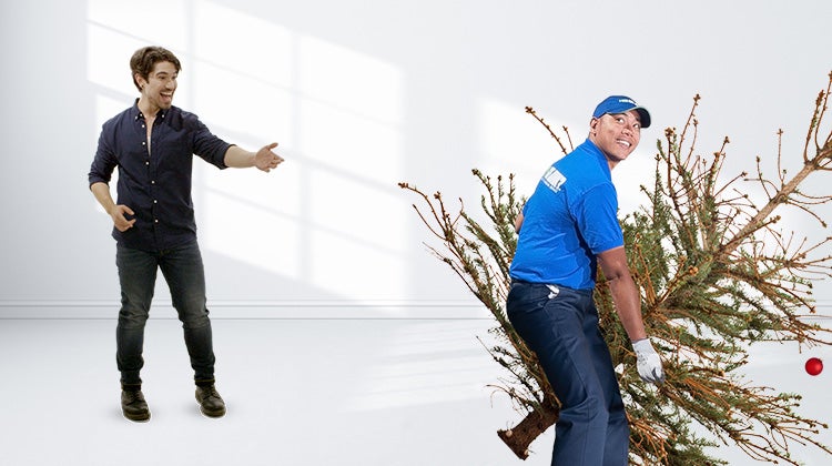 1-800-GOT-JUNK? team carrying a dry christmas tree away, while a man is standing beside them smiling