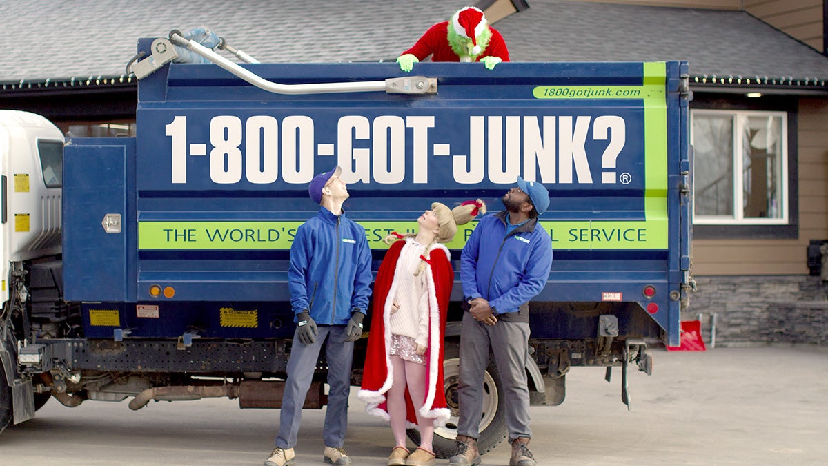 1-800-GOT-JUNK? team and Sarah McAllister standing in front of a junk removal truck