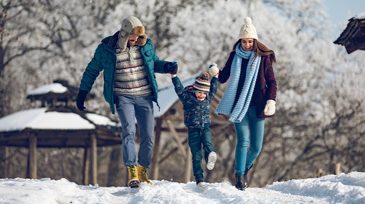 Parents playing with their child in the snow