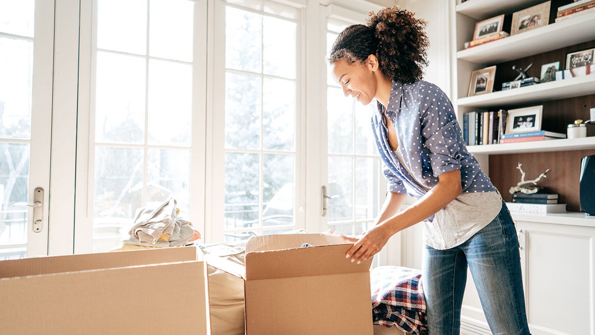 woman packing items in cardboard boxes