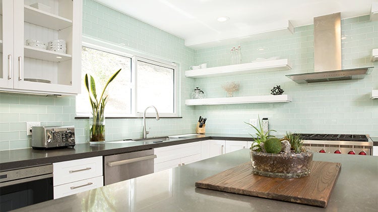 Clean open concept kitchen with blue back splash 