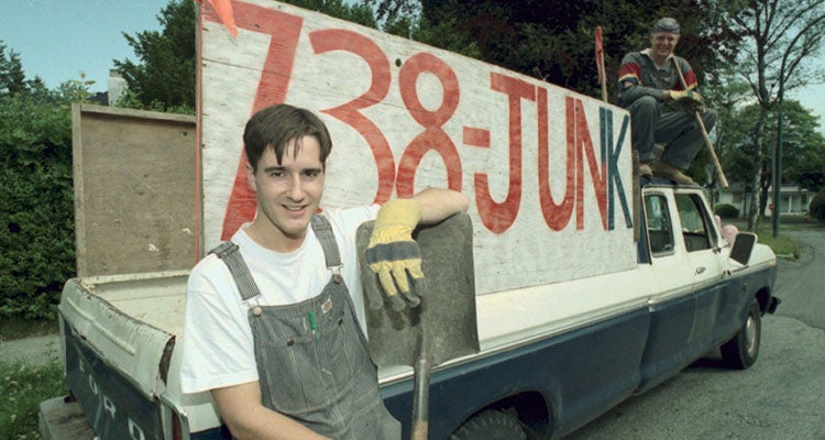 Young Brian Scudamore posing with his first junk truck
