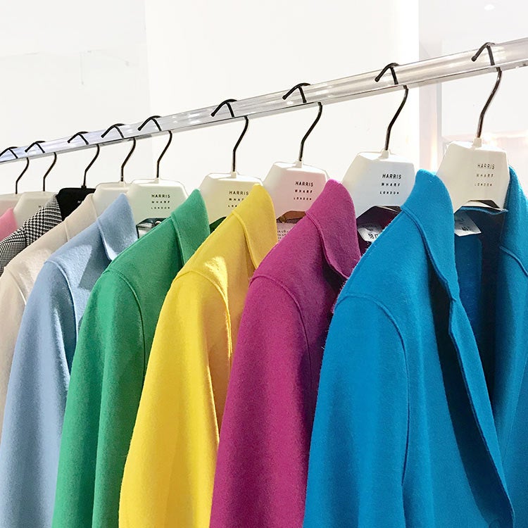 Colorful jackets on white hangers 