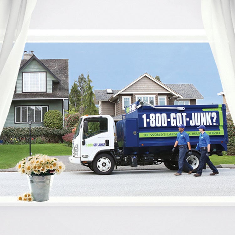 1-800-GOT-JUNK? truck outside an open window with flowers 