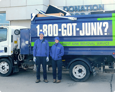 1-800-GOT-JUNK? team at a donation drop off with a full junk removal truck