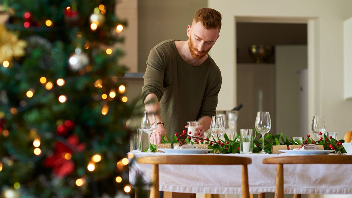 Young man setting up a christmas table