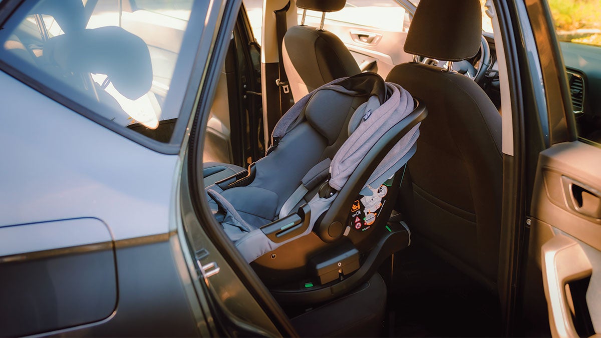A baby car seat in the back seat of a car