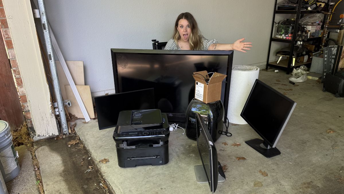 A woman with a pile of old electronics.