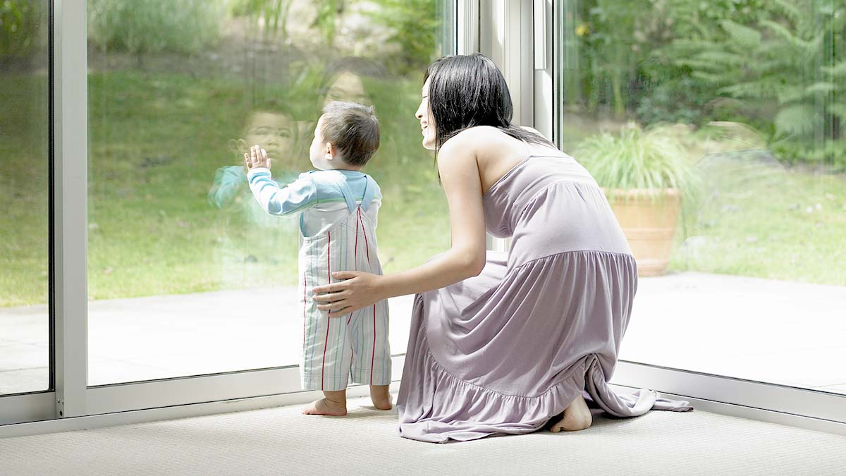 A mother an Son looking through a new glass door after replacing the old broken glass