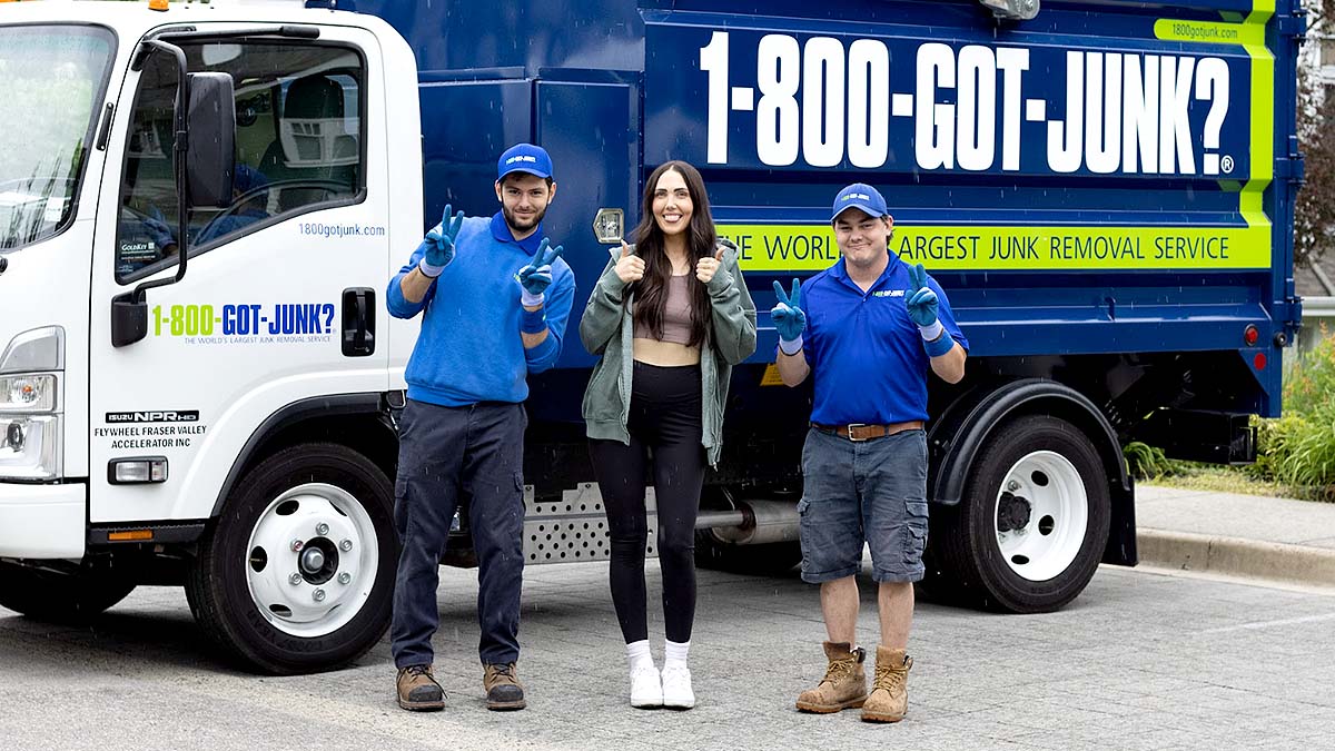 Bailey Stanworth and two 1-800-GOT-JUNK? truck team members smiling in front of the truck