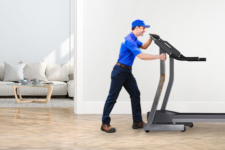 An old treadmill being removed by 1-800-GOT-JUNK? team member