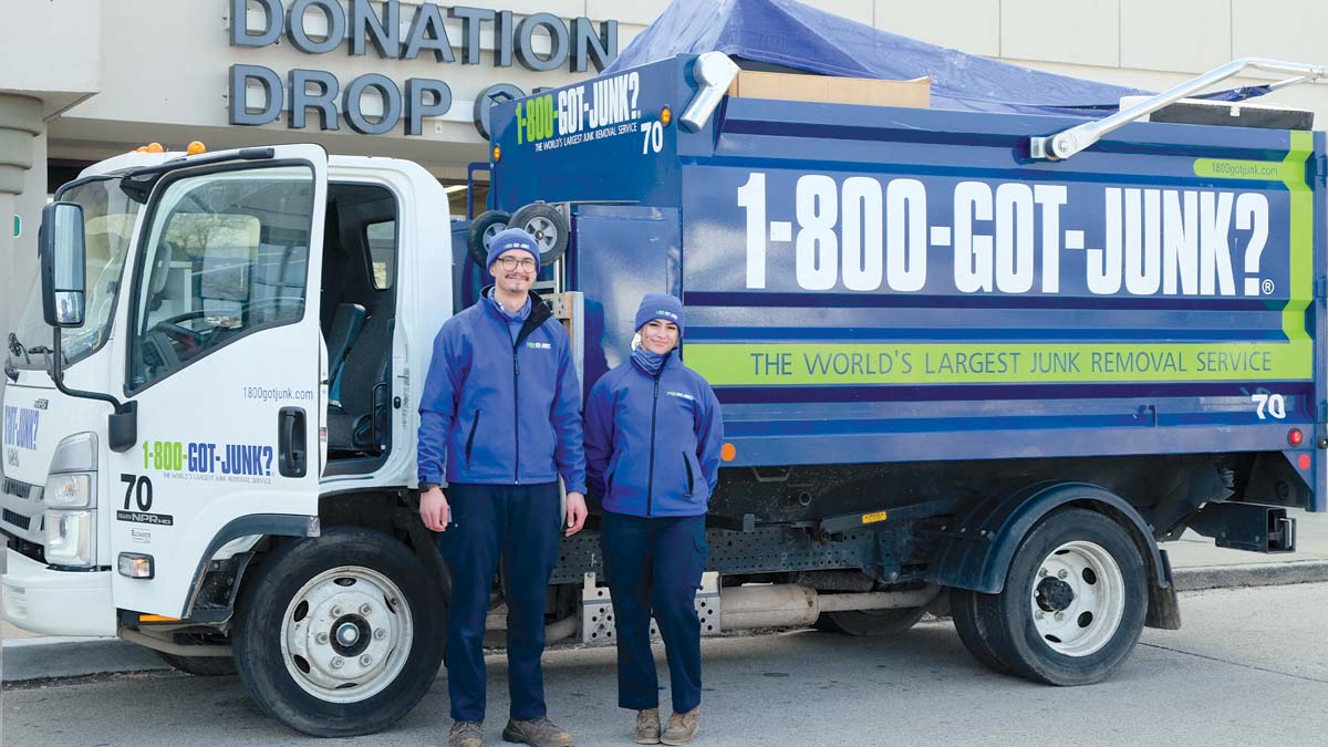 Repurpose Two truck team members standing in front of 1-800-GOT-JUNK? truck at donation drop off facility