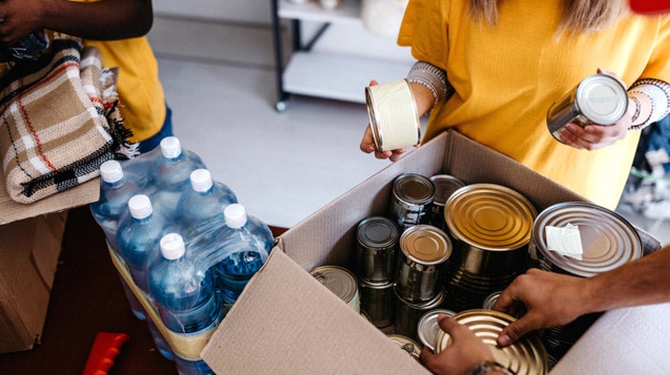 Women packing various jars in a box