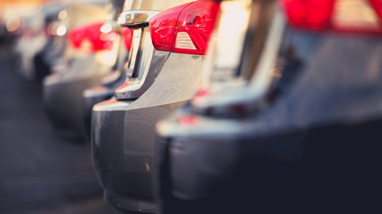 Row of silver cars with red taillights