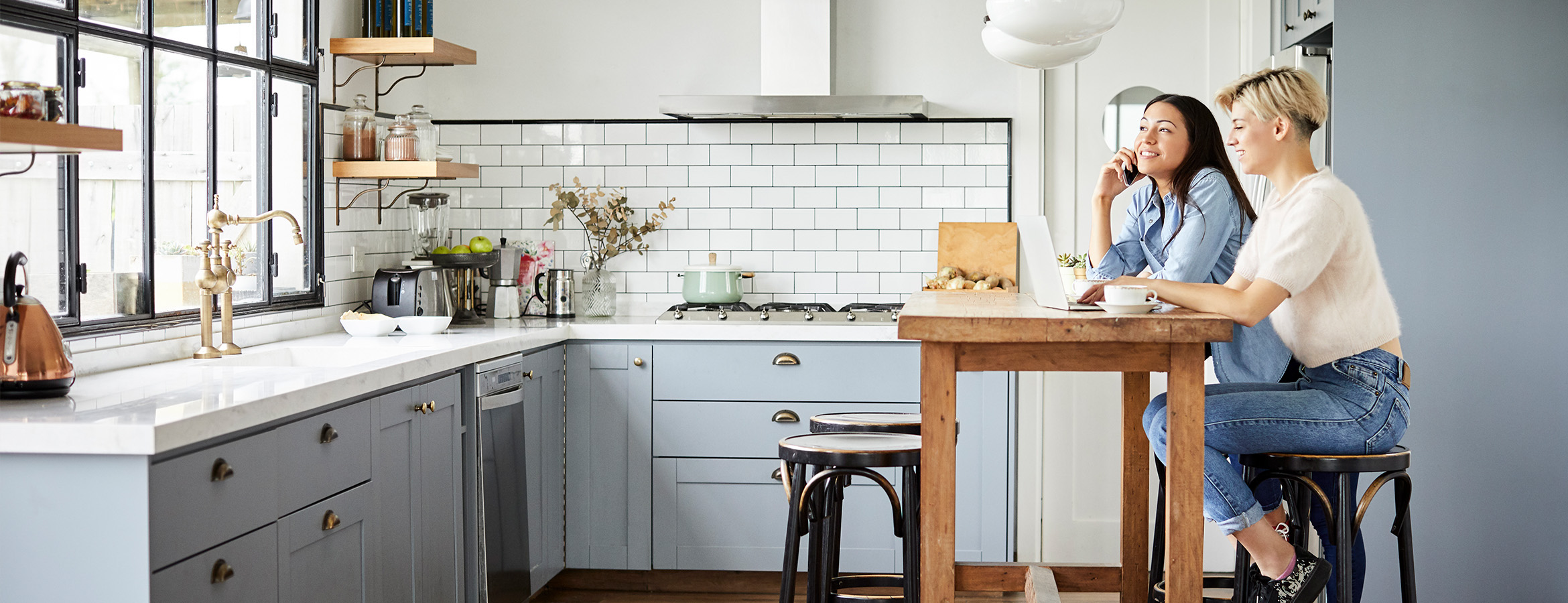 Two people sitting in bright clean kitchen
