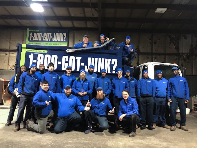 20 1-800-GOT-JUNK? St. Louis team members posing in front of a junk removal truck