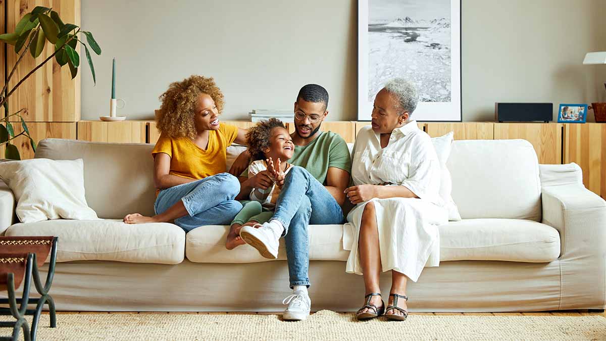 Family of four people sitting comfortable on a large couch