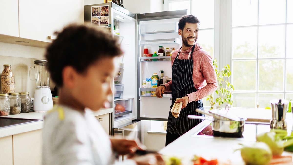 A father and son in their kitchen with a new refrigerator