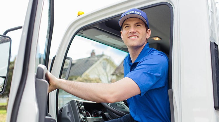 1-800-GOT-JUNK? Truck Team Member opening the truck door and smiling