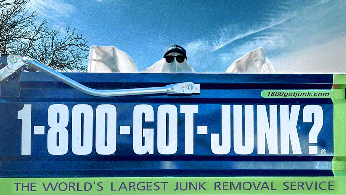 1-800-GOT-JUNK? truck with a person dressed as a ghost appearing in the truck bed
