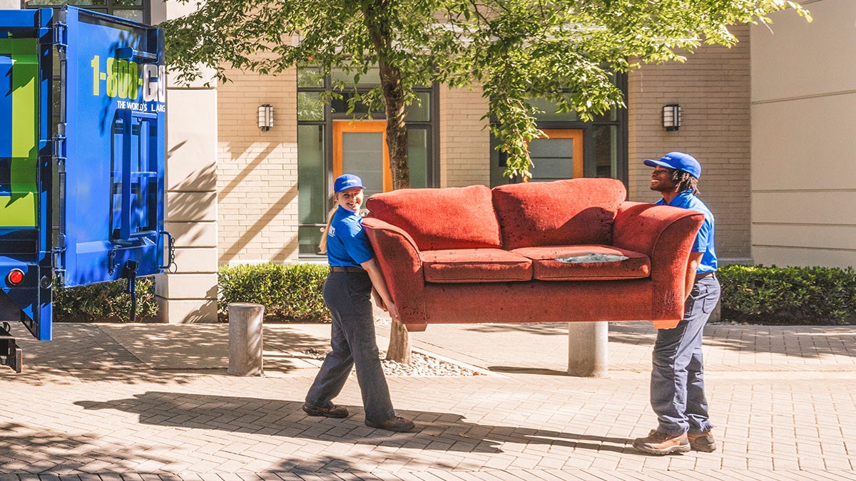 1-800-GOT-JUNK? crew taking a couch for donation