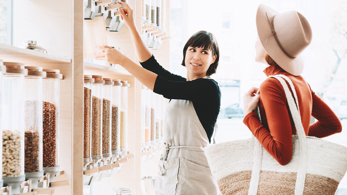 Saleswoman pouring coffee grounds for a customer