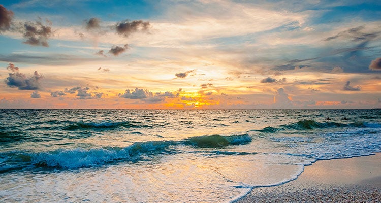 Beach sunset with ocean and setting sun