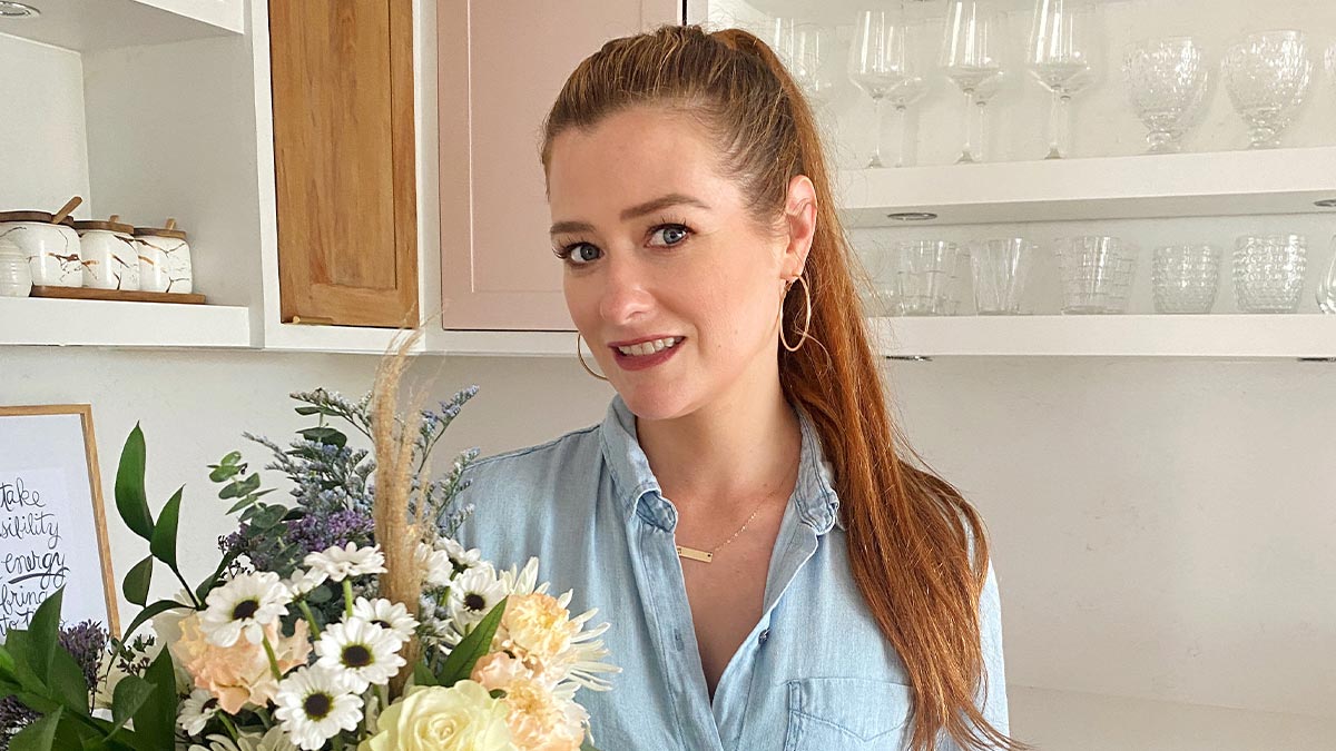 DIY Mom Rebekah Higgs smiling with flowers
