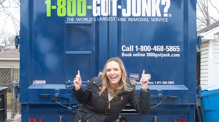 Casey Finn smiling in front of a 1-800-GOT-JUNK? truck