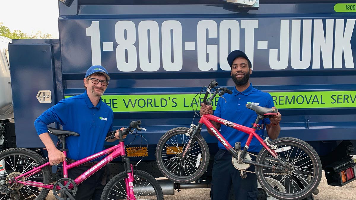 Two 1-800-GOT-JUNK? team members holding bikes