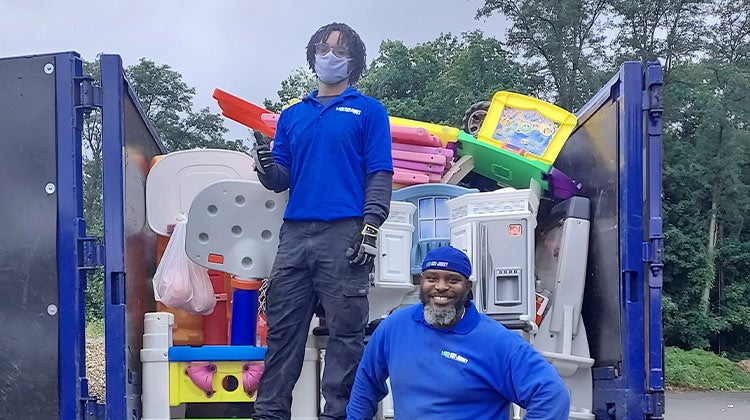 Two 1-800-GOT-JUNK? team members with truck full of toy donations