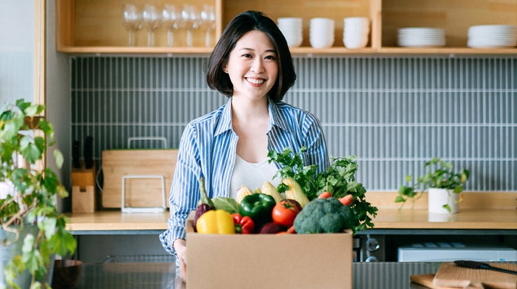 Woman with a grocery delivery box Woman with a grocery delivery box