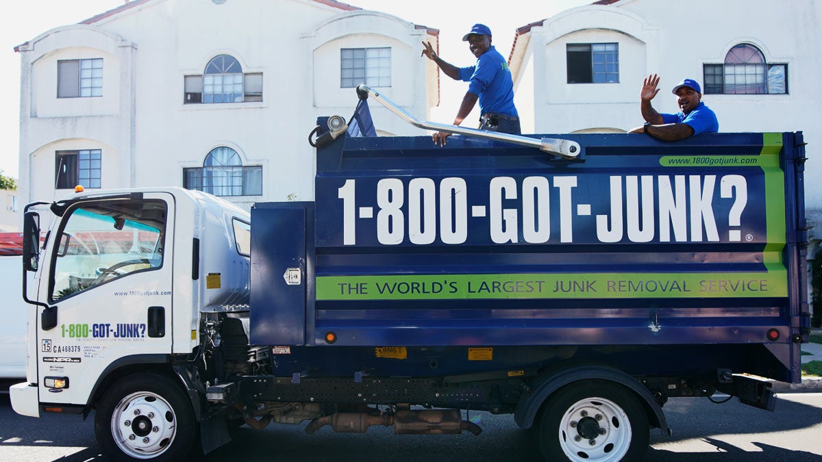 Truck Team Members waving inside of a 1-800-GOT-JUNK? truck