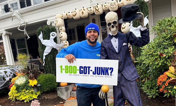 Spooky Junk - Fancy Skeleton A 1-800-GOT-JUNK? Truck Team Member by a skeleton.