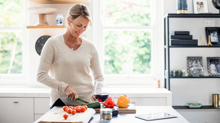 Woman cutting vegetables in her kitchen 