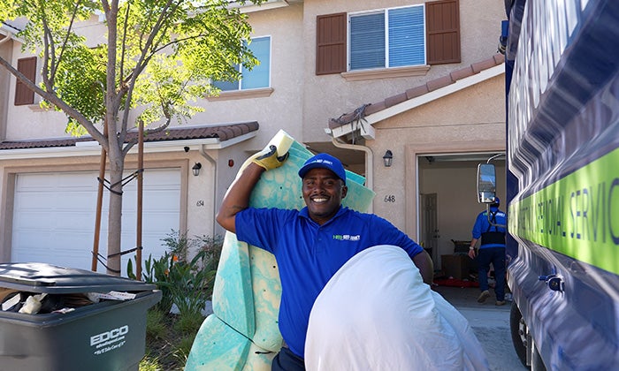 A 1-800-GOT-JUNK? Truck Team Member removing junk from a customer's home.