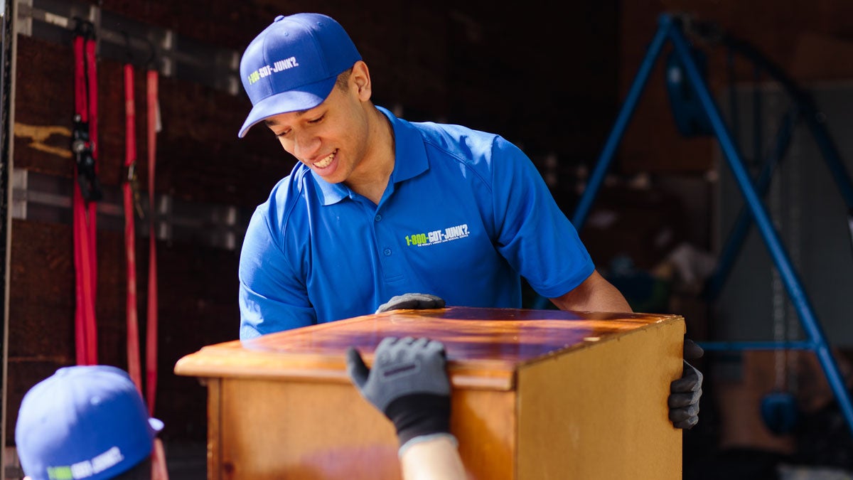 1-800-GOT-JUNK? crew removing a cabinet furniture item