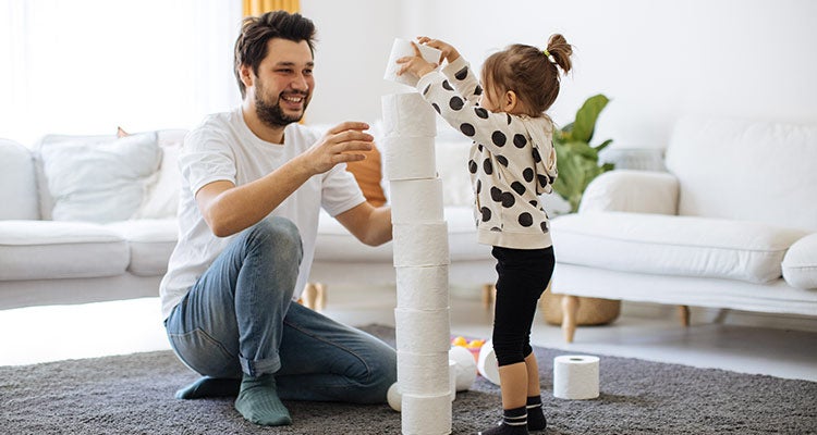 Father and daughter stacking toilet paper