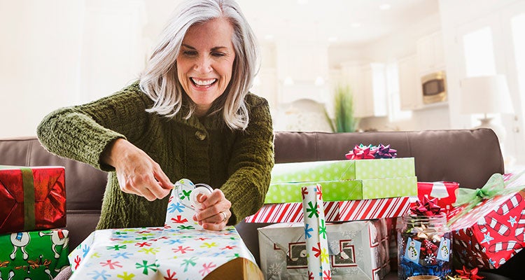 Woman happily wrapping holiday presents