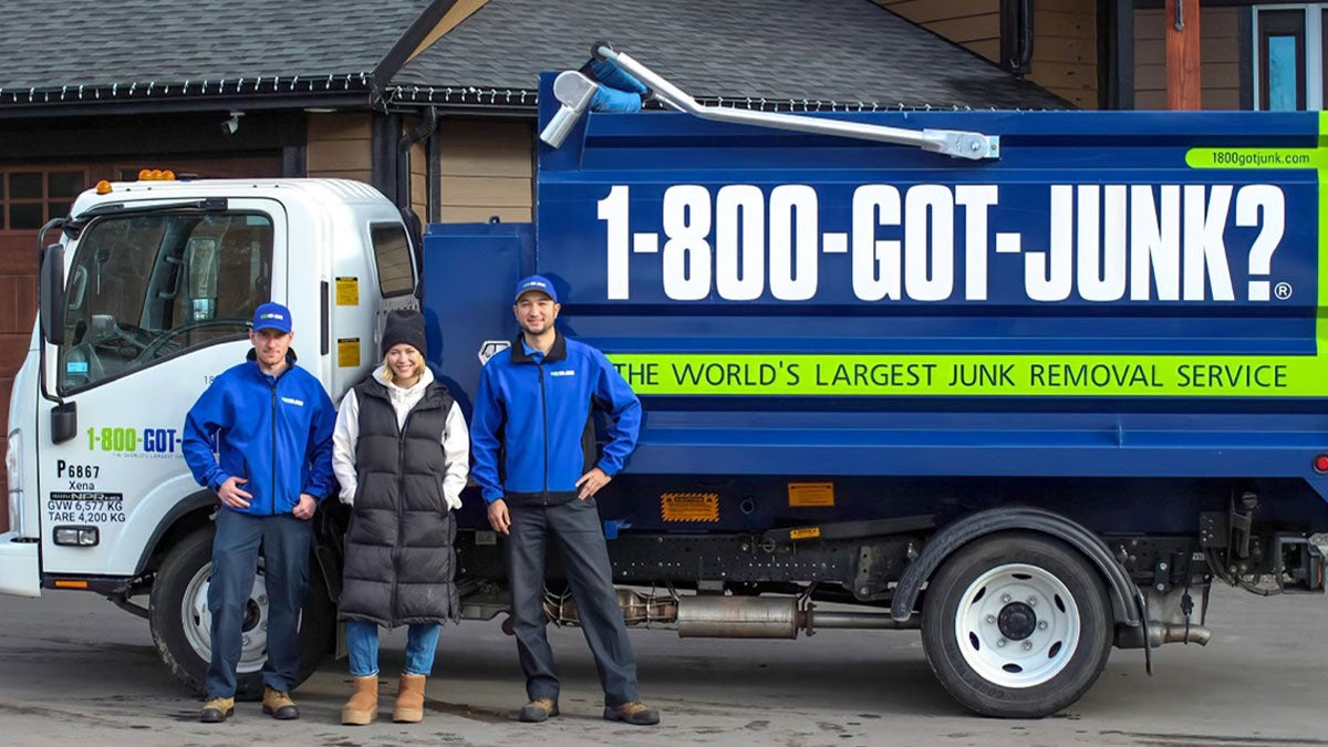 Sarah and two truck team members standing in front of a 1-800-GOT-JUNK? truck