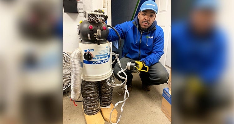 1-800-GOT-JUNK? Truck Team Member posing with a homemade robot