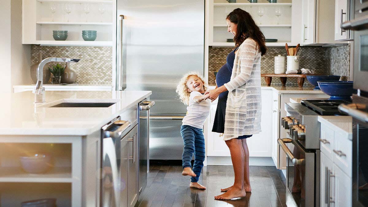 Mother and child dancing in a clean kitchen