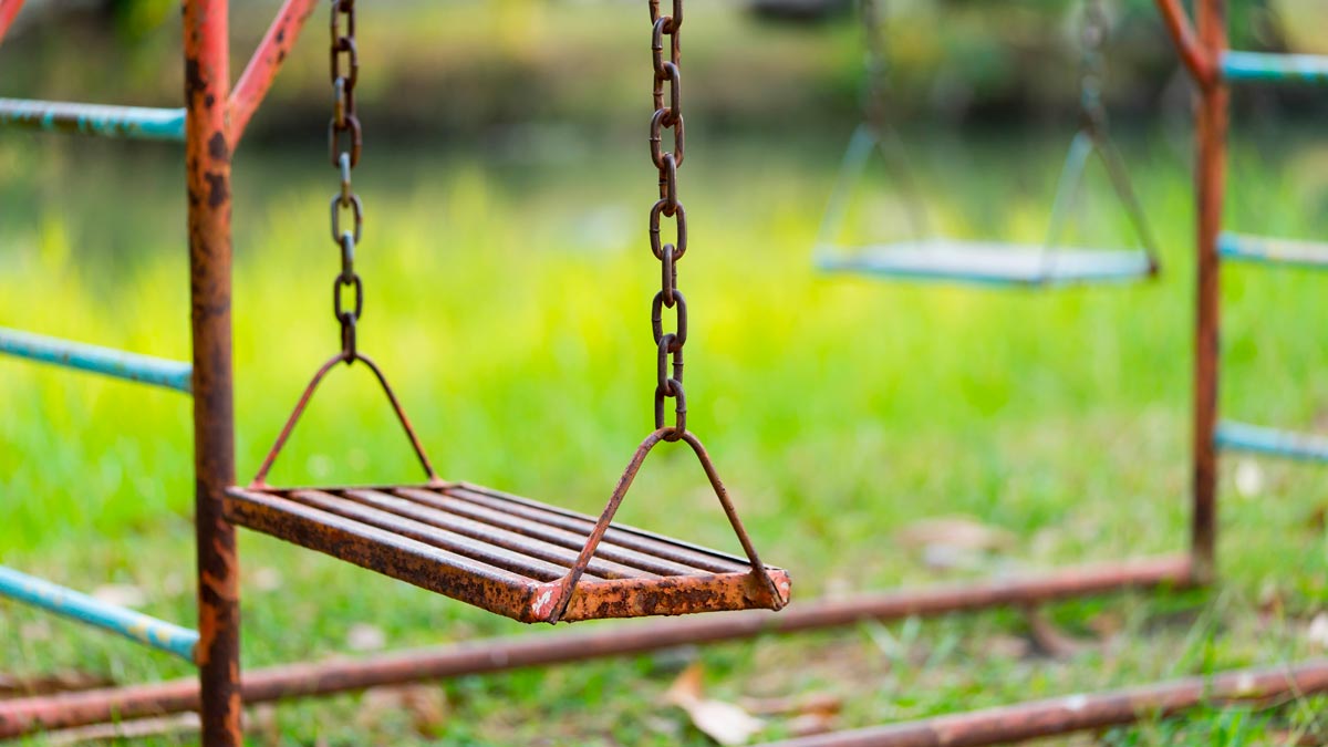 Old rusted swing that is part of a kid's playground