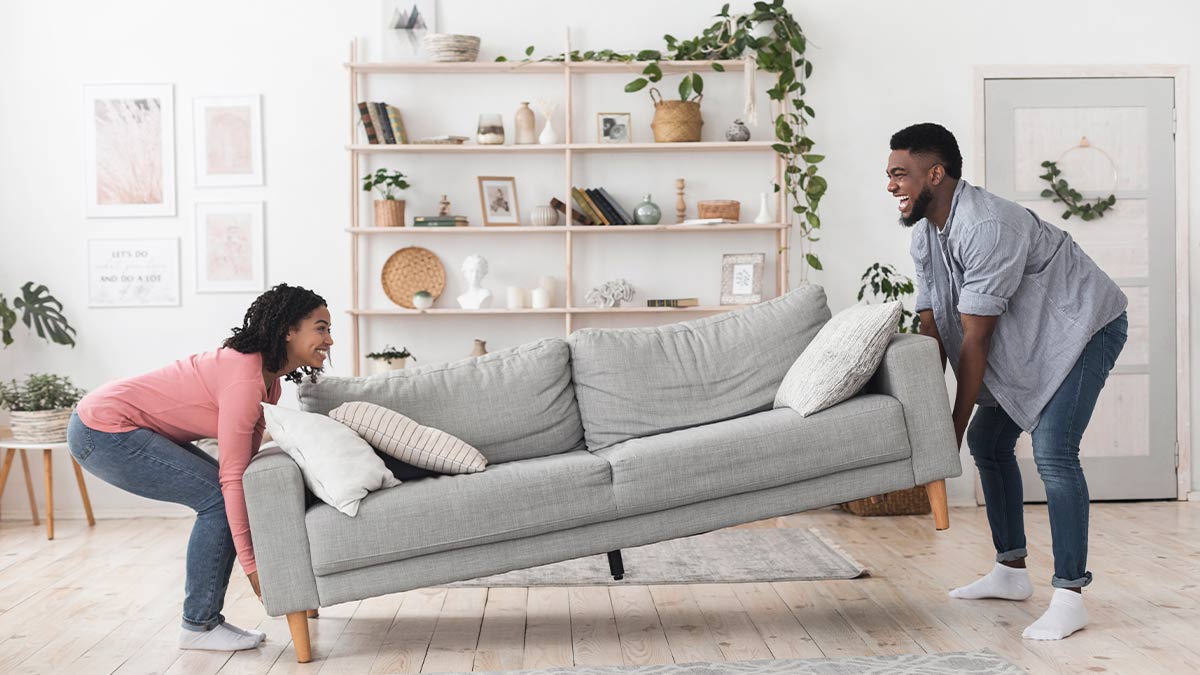 couple lifting grey couch