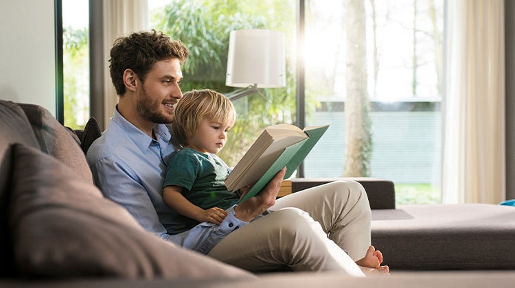 father and son reading in living room