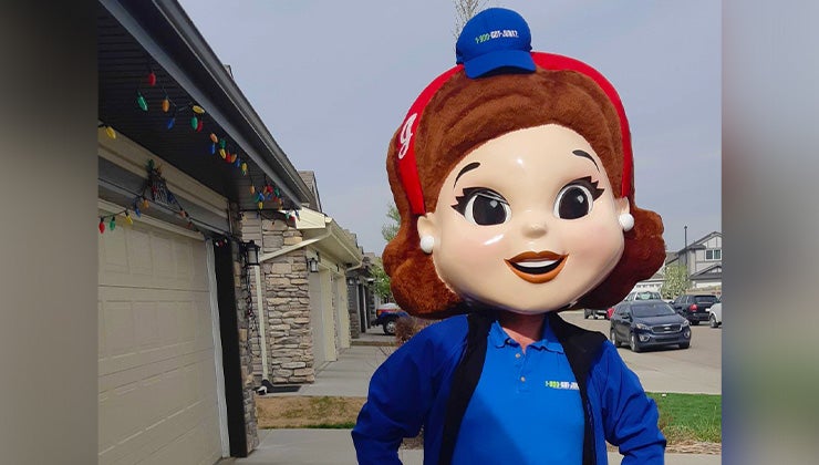 1-800-GOT-JUNK? truck team member wearing a large smiling mascot head