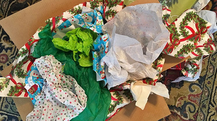 Cardboard box filled with crumpled holiday wrapping tissue