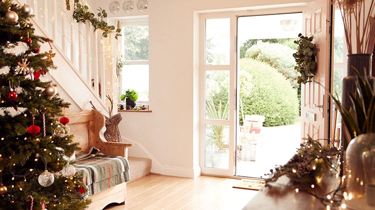 Open door in clean front entry way with holiday decorations