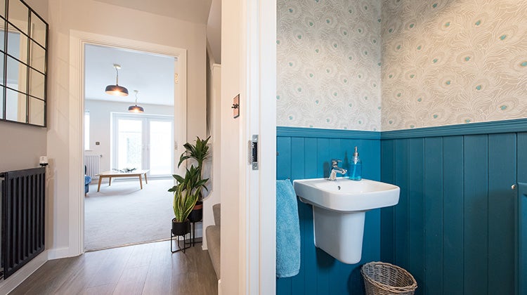 Clean half bathroom next to a clutter free hallway